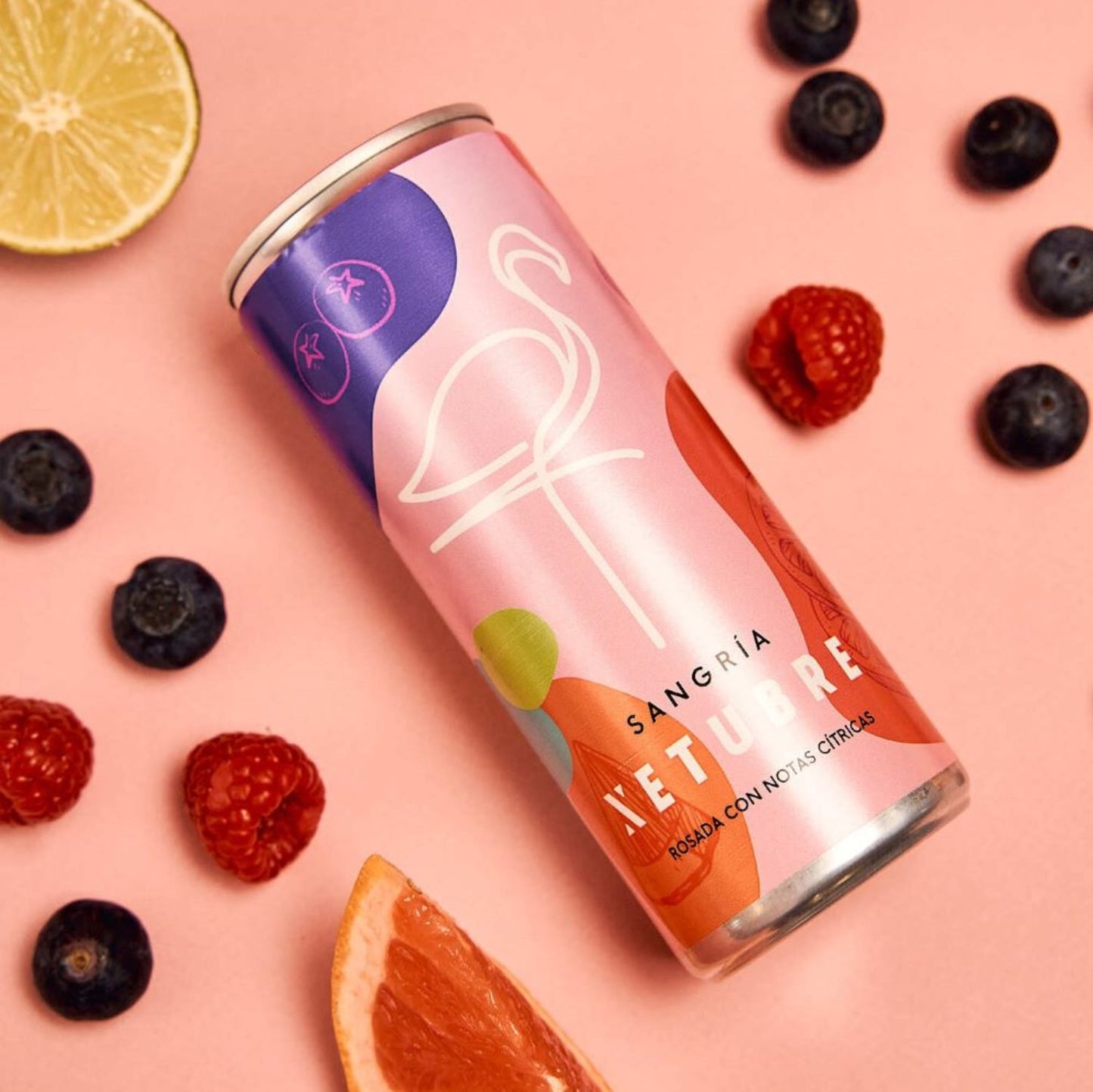 The Xetubre Sangria Rosé 250ml Can, designed with sleek abstract art and a flamingo outline, is beautifully showcased alongside blueberries, raspberries, a grapefruit slice, and a lemon wedge on a pastel background. Infused with Tempranillo grape essence, it provides a refreshing take on classic rosé wine.